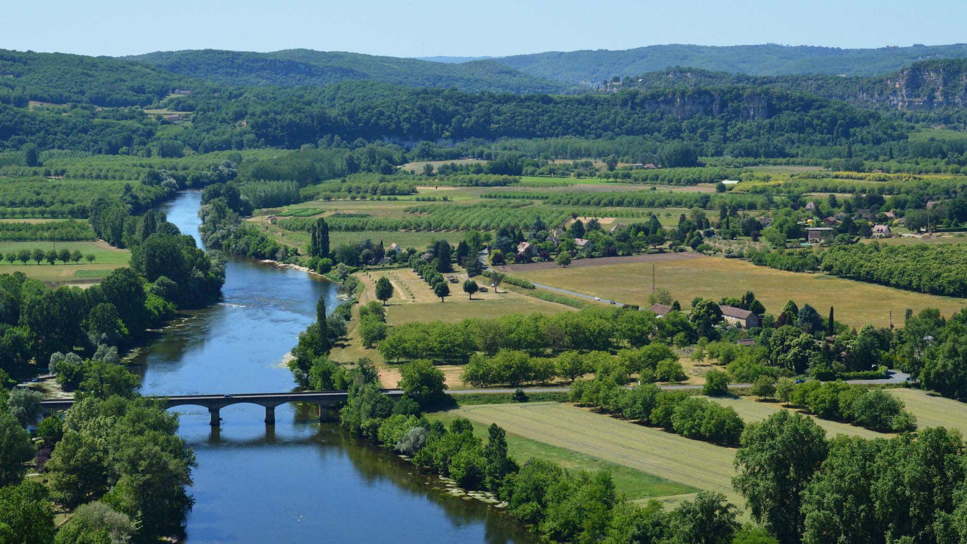 Letni widok na rzekę Dordogne wijącą się przez zielone wzgórza Francji