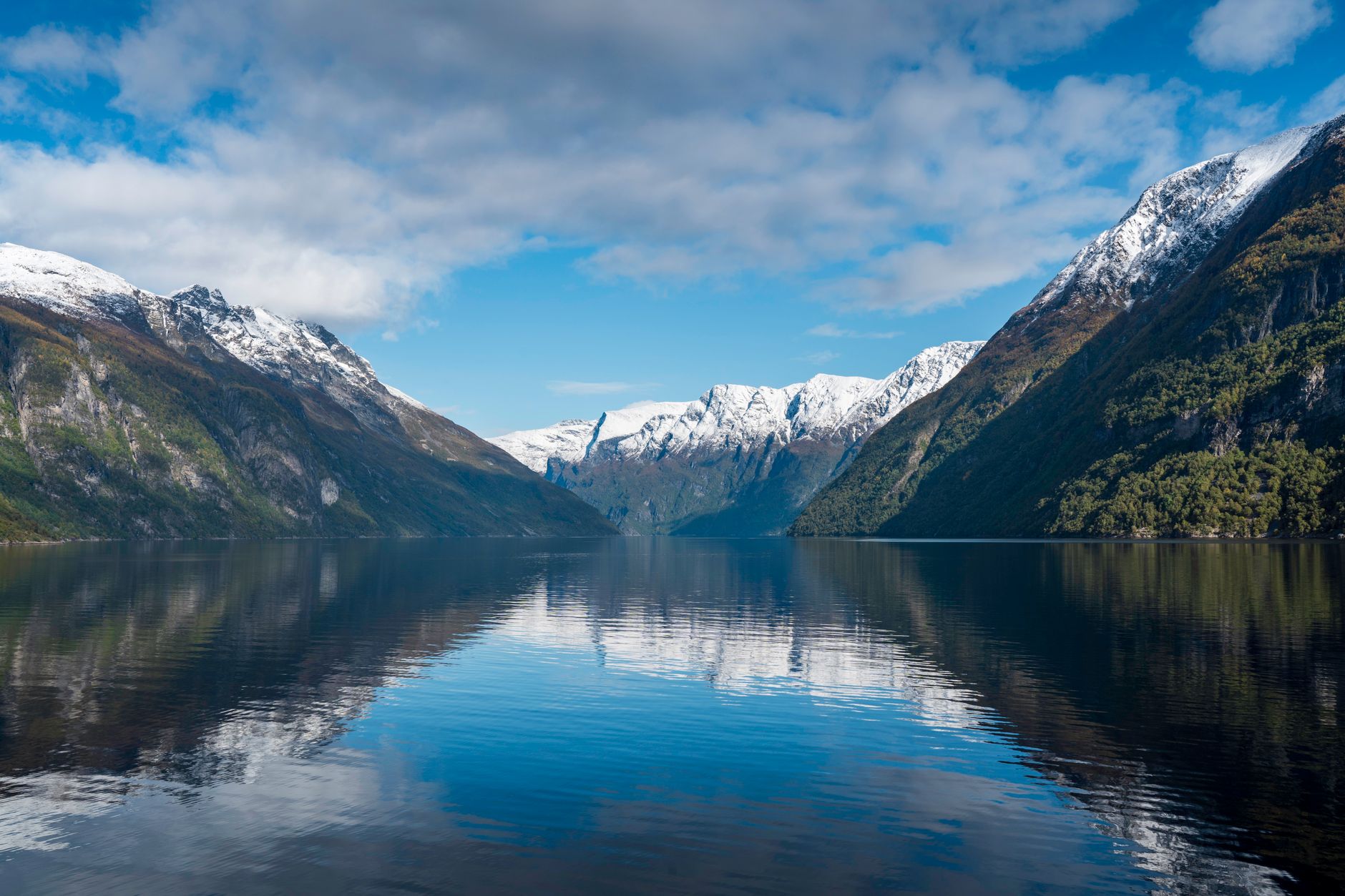 Spokojny norweski fiord otoczony górami odbijającymi się w wodzie